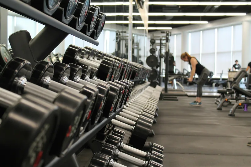 A gym floor with racks and barbells